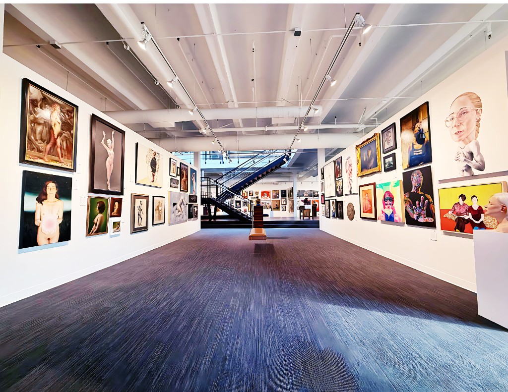 Wide interior of Art Love Salon, with paintings on both walls and open stairs in the center.